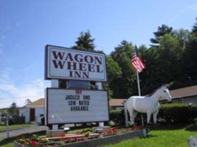 a sign for a wagon wheel inn with a horse statue at Wagon Wheel Inn in Lenox