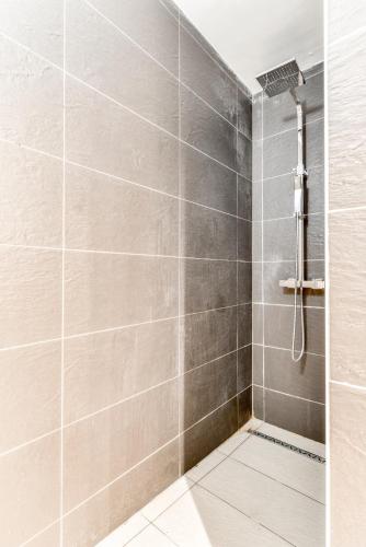une salle de bain avec douche aux carreaux gris dans l'établissement El king - central - tout à pied - wifi -netflix, à Carcassonne
