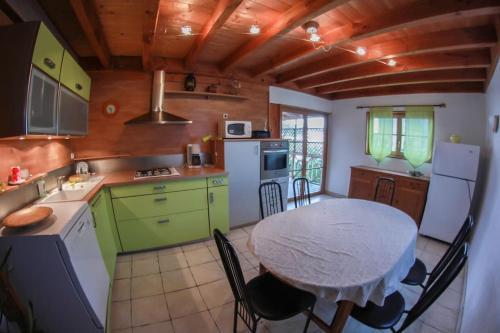 une cuisine avec une table et des placards verts dans l'établissement Appartement en duplex dans chalet à Talloires, à La Pirraz