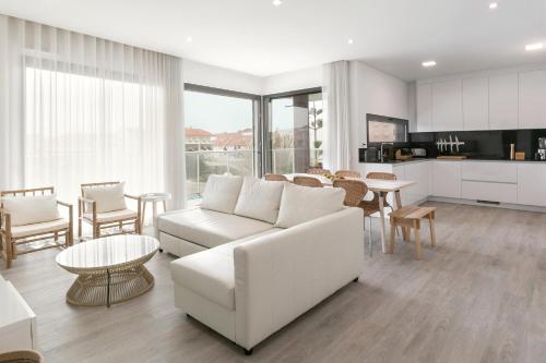 a living room with a white couch and a table at Consolação Wave Beach House in Atouguia da Baleia