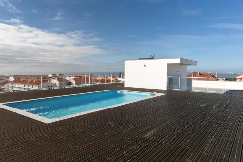 a swimming pool on the roof of a building at Consolação Wave Beach House in Atouguia da Baleia