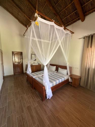 a bedroom with a bed with a mosquito net at Vilancool Beach Resort in Vilanculos