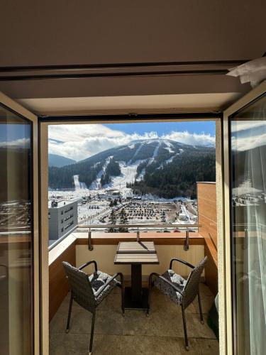 a balcony with a table and chairs and a view at Bjelasnica Apartment with the most beautiful view in Bjelašnica