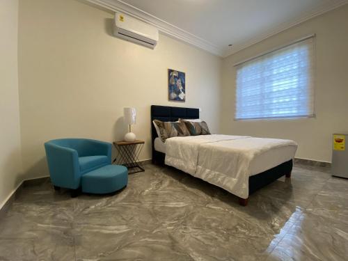 1 dormitorio con 1 cama y 1 silla azul en EAGLE VAULT (THE NEST FACILITY), en Accra