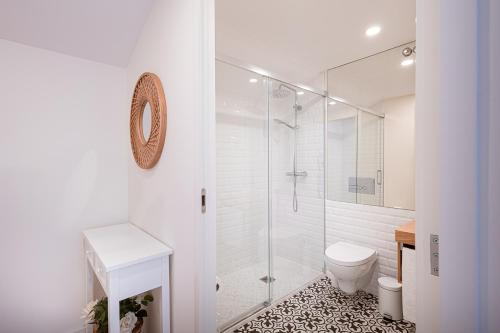 a white bathroom with a shower and a toilet at Quinta Das Essências in Penafiel