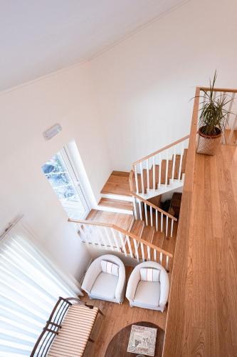 a staircase in a house with two white chairs at Quinta Das Essências in Penafiel