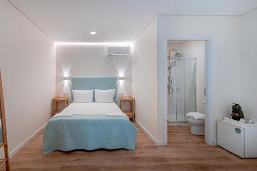 a white bedroom with a bed and a toilet at Quinta Das Essências in Penafiel