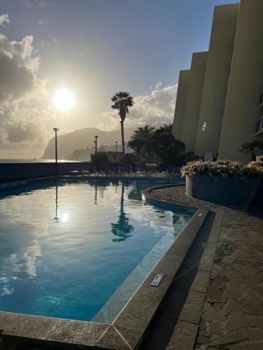 a swimming pool in front of a building at Atlantic Gardens Beach - atlanticgardensbeach com in Funchal