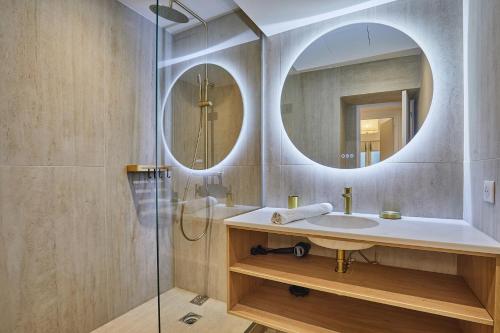 La salle de bains est pourvue d'un lavabo et de deux miroirs. dans l'établissement Résidense au coeur de Paris by Studio prestige, à Paris