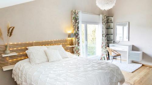 a bedroom with a white bed and a window at Chambre Lumineuse Dans Une Maison Moderne in Treyvaux