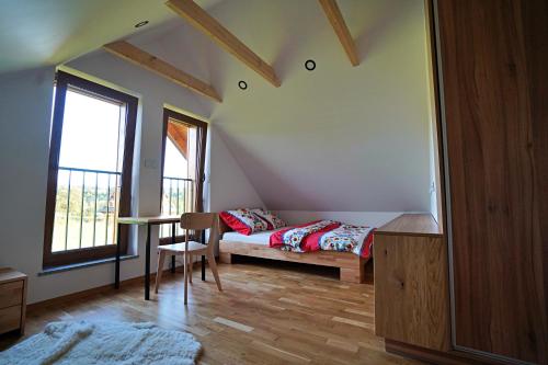 Uście GorlickieにあるKuźnia Nowicaのベッドルーム1室(ベッド1台、テーブル、窓付)