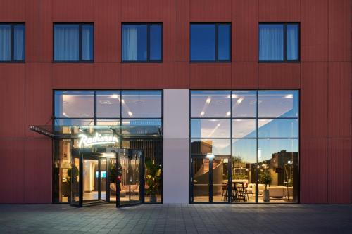 a red building with glass windows and a table at Radisson Hotel Budapest BudaPart in Budapest