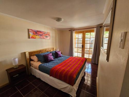 um quarto com uma cama com um cobertor colorido em Anka Lodge Quitor em San Pedro de Atacama