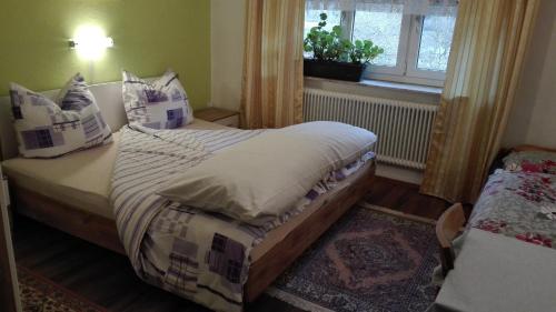 a bedroom with a bed with pillows and a window at Haus Agerer FEWO 2. Stock in Tarrenz