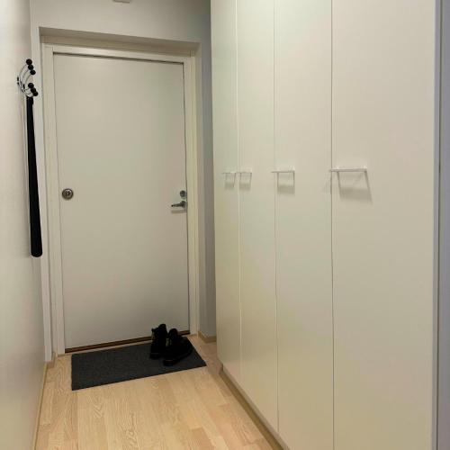 a room with a door and a black cat sitting on the floor at Pramea Apartments Pikku Pietari in Kuopio