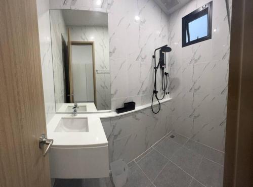 a white bathroom with a sink and a mirror at HomeHug@ChiangRai in Chiang Rai