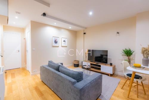 a living room with a couch and a tv at Magnifique appartement à 10 min de l'aéroport Orly in Villeneuve-le-Roi