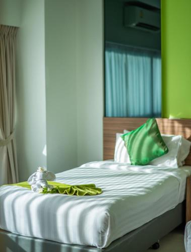 a bedroom with a bed with green and white sheets at The Lantern Resorts Patong - SHA Extra Plus in Patong Beach