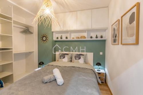 a bedroom with a large bed with white and green walls at Magnifique appartement à 10 min de l'aéroport Orly in Villeneuve-le-Roi