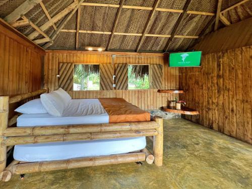 a bedroom with two beds in a wooden room at Tayrona Cachaco River Ecohostal in El Zaino