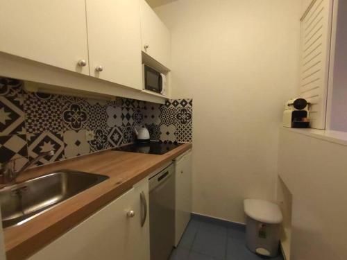 une cuisine avec un évier et un plan de travail dans l'établissement 7 min walk Metro ApartHotel, La Defense+Parking, à Courbevoie