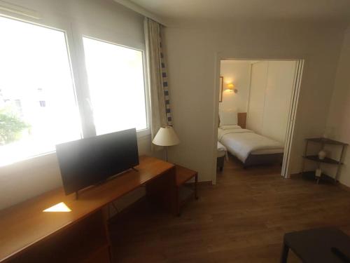 - un salon avec une télévision et un lit dans l'établissement 7 min walk Metro ApartHotel, La Defense+Parking, à Courbevoie