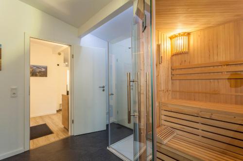 a glass pivot door in a room with a walk in shower at Ferienhaus Möhnesee in Möhnesee