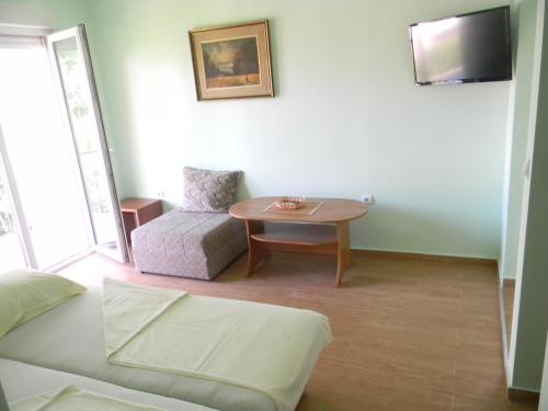 a living room with a table and a chair at Gospostina Apartments in Budva