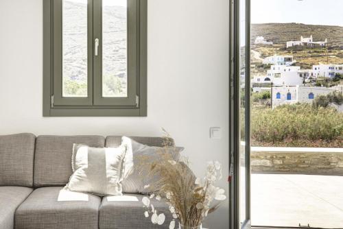 a living room with a couch and a window at Tinos Treasures Apart-Hotel in Istérnia