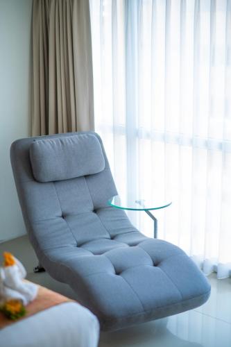 a blue chair in front of a window with a table at The Lantern Resorts Patong - SHA Extra Plus in Patong Beach