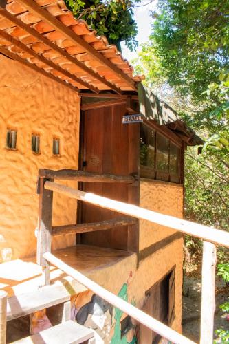 a building with a wooden door on the side of it at Lagarto Na Banana Hostel in Pipa