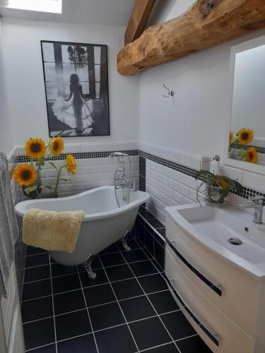 uma casa de banho com uma banheira branca, um lavatório e um espelho. em A Barn with a View and Tranquility em Varaignes