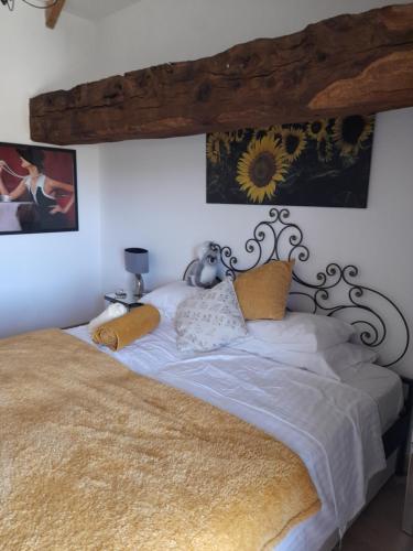 um quarto com uma cama grande e lençóis brancos em A Barn with a View and Tranquility em Varaignes