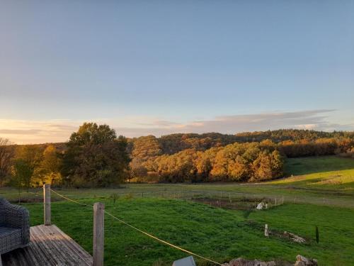 uma vista para um campo com árvores ao fundo em A Barn with a View and Tranquility em Varaignes