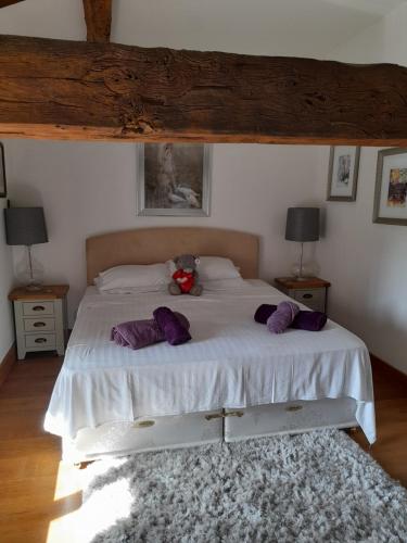 um quarto com uma cama com um urso de peluche em A Barn with a View and Tranquility em Varaignes