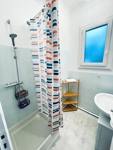 une salle de bain avec un rideau de douche et un lavabo dans l'établissement DOLCE VITA Plein coeur St Brevin proche plages, à Saint-Brévin-les-Pins