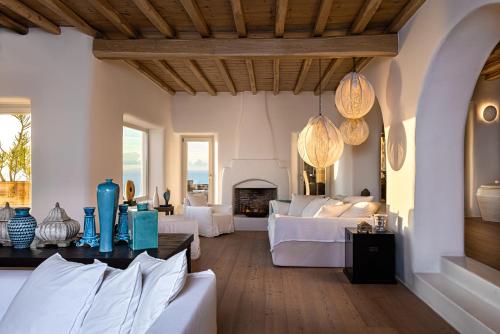 un soggiorno con mobili bianchi e un camino di Villa Montessito Mykonos a Tourlos