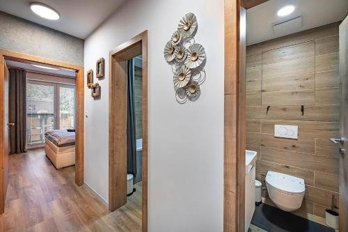 uma casa de banho com um WC e um espelho. em Apartments Centrum Hviezdoslav em Poprad