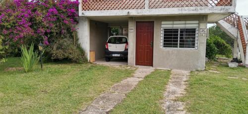 a car parked outside of a house with a red door at La Isla - Araminda in Araminda