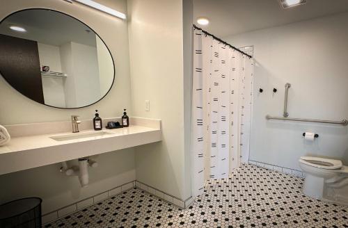 een badkamer met een wastafel, een spiegel en een toilet bij Brewhalla Hotel in Fargo