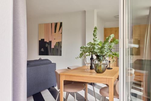 a dining room table with a vase with a plant on it at Emma - Walldürn-Glashofen in Walldürn