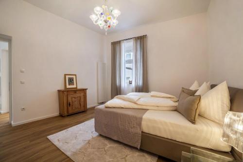 - une chambre avec un grand lit et un lustre dans l'établissement Amort Suites, à Merano