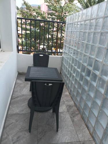 a small black table and chair on a balcony at T2 Cosy Nouvelle Route Bastos Yaoundé in Yaoundé