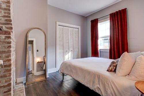 um quarto com uma cama grande e um espelho em The Crescent City Cottage em Nova Orleães