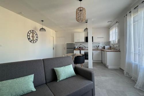 Il comprend un salon avec un canapé et une cuisine. dans l'établissement Le Gaïa - T2 de standing neuf, à Perpignan