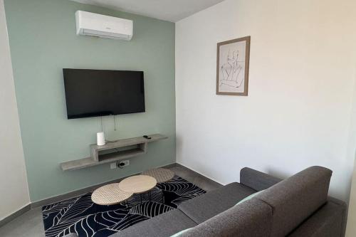 - un salon avec un canapé et une télévision dans l'établissement Le Gaïa - T2 de standing neuf, à Perpignan