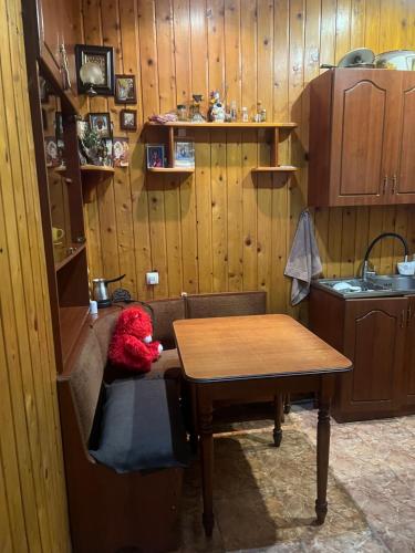un ours en peluche rouge assis sur une table dans une cuisine dans l'établissement ბინა, à Tbilissi