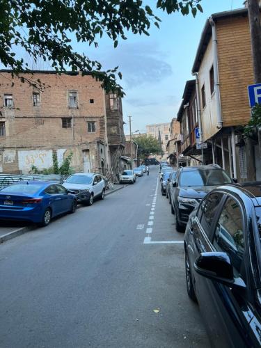 une rue avec des voitures garées sur le côté de la route dans l'établissement ბინა, à Tbilissi