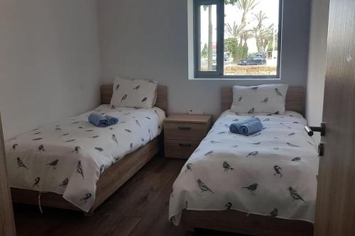um quarto com 2 camas individuais e uma janela em luxueux appartement touristique em Agadir
