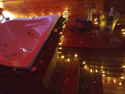 bañera roja en una habitación con luces en Chalé lua cheia, en Flores da Cunha